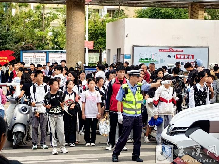 指挥交通护送学生安全过马路。通讯员 周发兴 摄