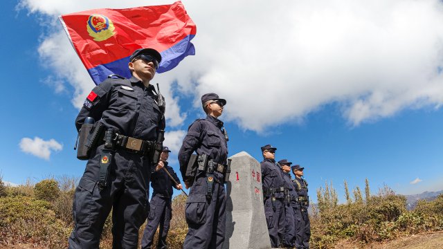 共和国一号界碑旁，腾冲出入境边防检查站民警与警旗同框 徐健勋摄影.jpg